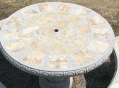 a stone table sitting on top of a gravel field