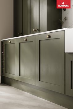 an image of a kitchen setting with green cabinets and white countertop space for the sink