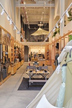 the inside of a building with tables, chairs and umbrellas hanging from the ceiling