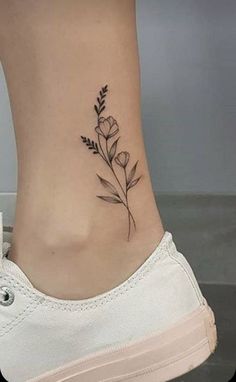 a small flower tattoo on the side of a woman's lower back ribcage