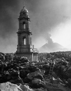 an old photo of a tower on top of a mountain