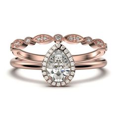 a rose gold engagement ring set with a pear shaped diamond in the center and two matching wedding bands