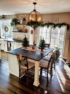 a dining room table and chairs with christmas decorations on the counter top in front of an open kitchen door