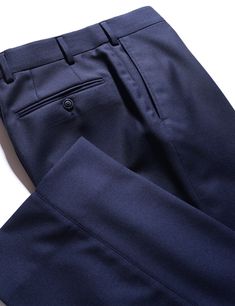 When selecting a separate trouser, you want something that can wear many hats and be a workhorse in your wardrobe. This Super 130s wool cloth is a classic, understated twill weave in a sturdier construction, giving it an understated look, solid drape and high level of durability suitable for frequent wear. Consider this a go-to, do-anything staple in your wardrobe that you can dress up or down as the occasion demands. FABRIC AND TRIMS: Woven in Italy by Drago, this Super 130s wool twill is made from a slightly thicker yarn, and woven with a dense construction, to give it a sturdy, substantial drape, while still preserving a soft, luxurious feel. 100% wool - Super 130s yarn count 310 grams/meter SEASONALITY: A medium-heavy weight suitable for any time of year, but perhaps not the very hotte Navy Fitted Dress Pants For Work, Elegant Fitted Navy Dress Pants, Tailored Elegant Navy Pants, Classic Navy Dress Pants For Business Casual, Elegant Tailored Navy Pants, Classic Blue Winter Bottoms, Tailored Navy Dress Pants With Welt Pockets, Navy Tailored Dress Pants With Welt Pockets, Classic Wool Dress Pants For Formal Occasions