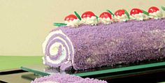 a purple cake with white frosting and cherries on top