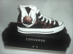 a black and white converse shoe with an apple painted on it