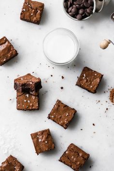 chocolate brownies and milk on a white surface