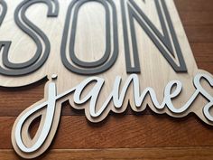 a wooden sign that says son james on the side of a building with wood flooring