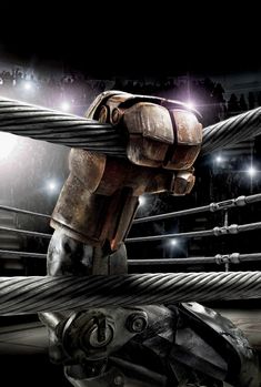 a robot is standing in the middle of a boxing ring with his arm wrapped around a rope