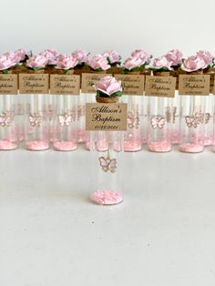 there are many wine glasses with pink roses in the bottom and name tags on them