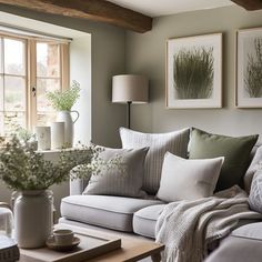 a living room filled with furniture and flowers on top of a coffee table in front of a window