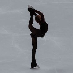 a figure skating on an ice rink wearing black