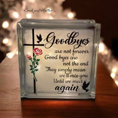 a glass block with an image of a cross and roses on it that reads goodbyes are not forever good byes are not the end they