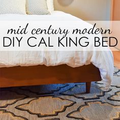 a bed with white sheets and pillows in a bedroom next to a wooden headboard that says mid century modern diy cal king bed