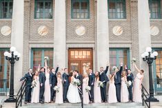 a large group of people standing on steps in front of a building with windows and doors