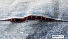 the hole in the jeans has been stitched with red thread