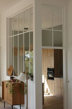 an open living room and kitchen area with large glass doors on the wall to let in natural light