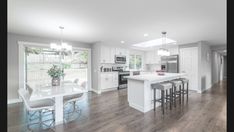 a large kitchen with white cabinets and an island in front of the stove top oven