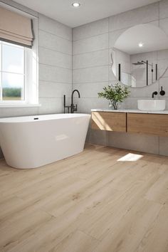 a white bath tub sitting next to a sink in a bathroom under a mirror on top of a wooden floor