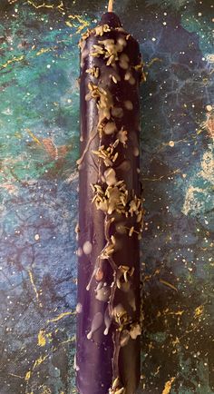 a purple candle with sprinkles on it