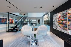 Chic hotel style design at modern Santa Monica LA home with open plan art filled interior. Art Loft, White Armchair, Floating Stairs, White Fireplace