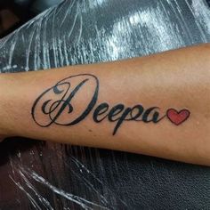 a person with a tattoo on their arm that says deepa and two hearts in the middle