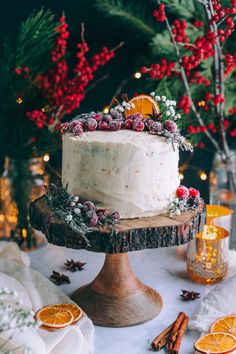 a white frosted cake sitting on top of a wooden table next to orange slices