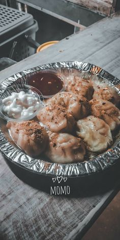 a metal plate filled with dumplings and sauce