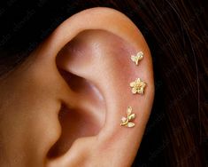 three small gold butterflies are attached to the ear