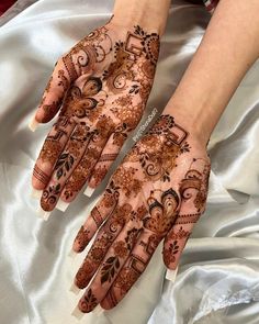 two hands with henna designs on them