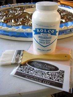 a bottle of roloco sits on a table next to a brush and palette