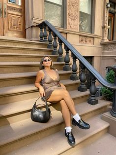 a woman sitting on the steps with her handbag