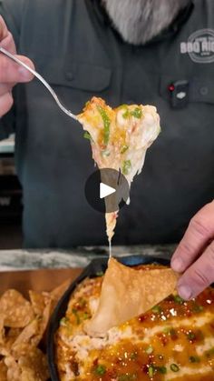 a person is eating some food out of a skillet with a fork in it