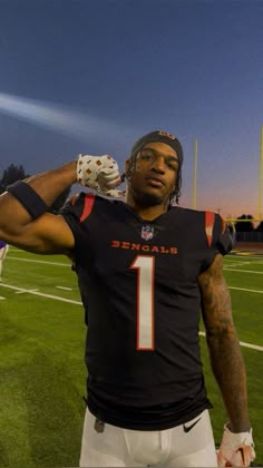 a man standing on top of a field wearing a football uniform and holding a glove