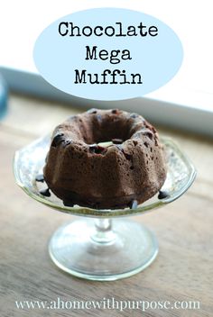 chocolate mega muffin on a glass cake plate with the words, chocolate mega muffin above it