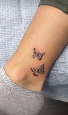 two small butterflies on the ankle tattoo design for women's feet, one is black and white