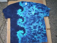 a blue tie - dyed shirt sitting on top of a cardboard box