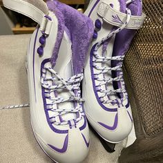 a pair of purple and white shoes sitting on top of a couch