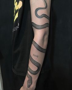 a man with a snake tattoo on his arm