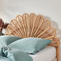 a wicker headboard with blue pillows on a bed