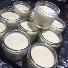 several jars filled with white liquid sitting on top of a counter