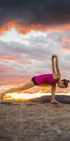 a woman is doing yoga on the beach