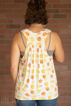 a woman standing in front of a brick wall with her back turned to the camera