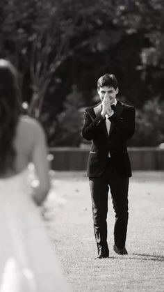 a man in a suit and tie standing next to a woman wearing a wedding dress