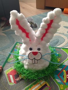 an easter bunny made out of yarn sitting on a rug