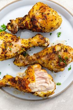 three pieces of chicken on a plate with parsley sprinkled around the edges