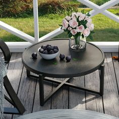 a bowl of flowers on a table with some chocolates in front of the window