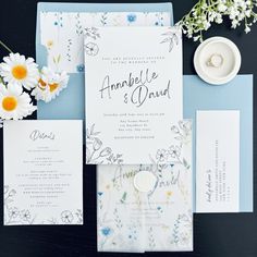 the wedding stationery is laid out with flowers