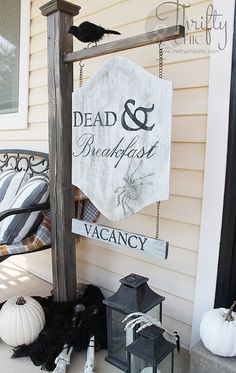 a sign that says dead and breakfast on the outside of a house with halloween decorations around it