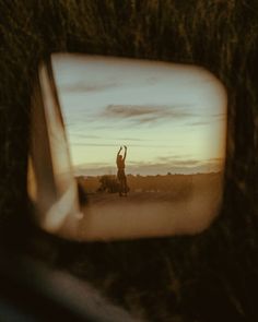 the reflection of a man standing in front of a car's side view mirror